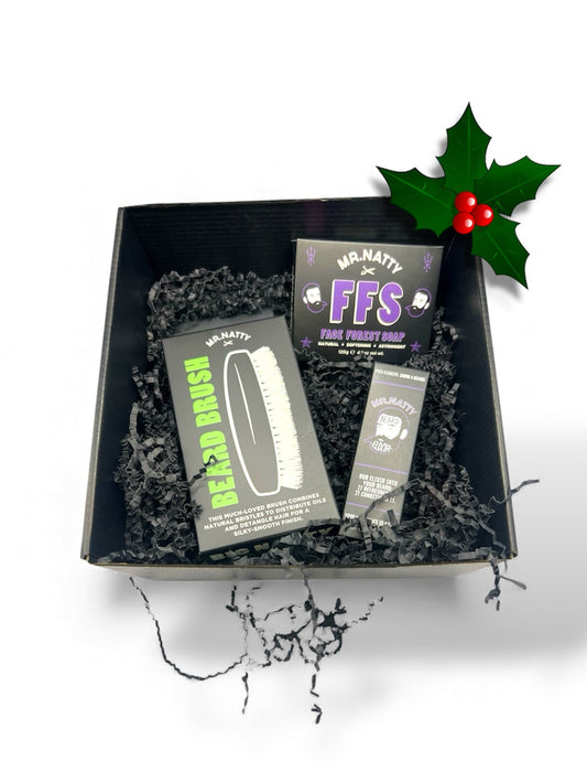 Black gift box with 'FMS' and 'RDM' products, holly leaf and berry decoration on a white background
